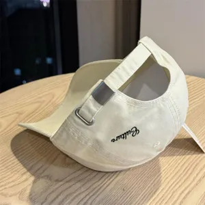Close-up detail of casual beige baseball cap with metal buckle and culture embroidery.