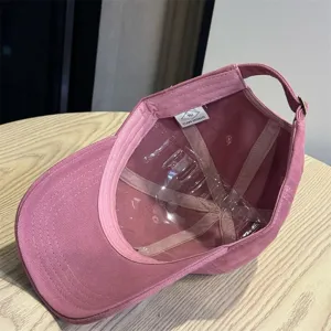 Detailed view of the pink washed cotton baseball cap inner structure and soft top design.