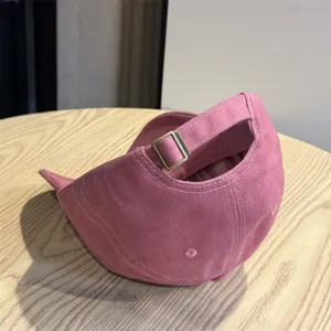 Detail view of the pink washed cotton baseball cap with adjustable metal strap buckle back.