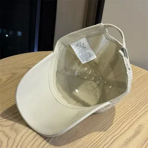 Beige cotton baseball cap featuring interior label and structured shaper for daily wear.