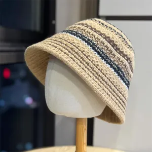 Vista detallada del sombrero de punto a rayas, mostrando una textura fina y un tejido muy suave.