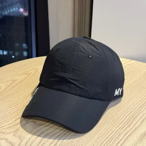 Detail view of the black quick-drying baseball cap with white embroidered letters.