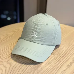 Vista detallada de la gorra de béisbol deportiva verde claro de secado rápido con bordado frontal.
