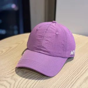 Close-up detail of the purple breathable grid baseball cap, showcasing fine fabric and embroidery.