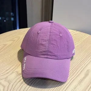 Purple quick-drying baseball cap with embroidered letters, detailed view of the fabric.