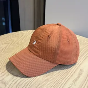 Detailed view of the lightweight orange ripstop baseball cap with front embroidery design.