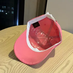 Detailoverzicht van roze sneldrogende honkbalpet met binnenlabel en verstelbare band.