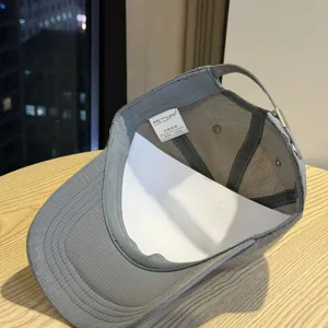Close-up view of the grey quick-dry baseball cap interior showing inner tag and mesh details.