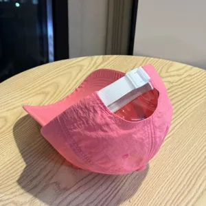 Close-up detail van de roze sneldrogende honkbalpet, met de verstelbare witte band goed zichtbaar.