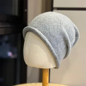 Primo piano dettaglio berretto morbido lavorato a maglia grigio con stelle in strass.
