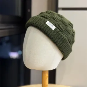 Gedetailleerde close-up van de donkergroene gebreide muts textuur, warme wollen beanie.