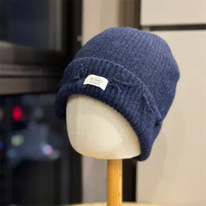 Dark blue knitted beanie hat close-up detail, soft wool winter warm headwear daily fashion accessory.