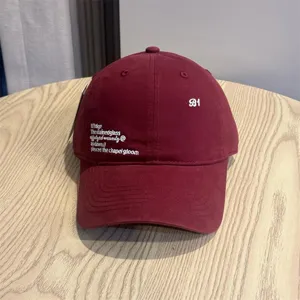 Retro burgundy baseball cap with white embroidered letters, casual street style hat for daily wear.