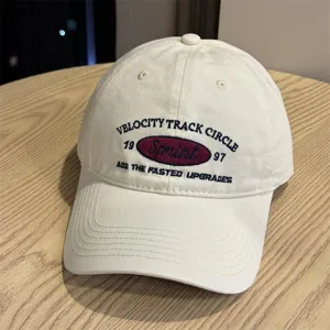 Vista detallada de la gorra de béisbol en beige con elegante bordado frontal y letras.
