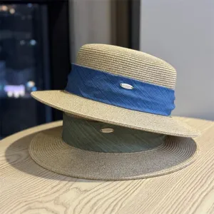 Stylish women's flat top straw hat with ribbon and metal badge, perfect for summer outdoor travel.