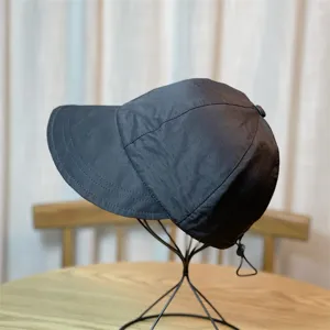 Vista de primer plano de sombrero negro de secado rápido con ala extendida y cordón ajustable.