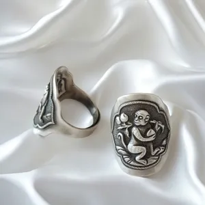 Gedetailleerd close-up van de vintage Chinese dierenriem aap snijwerk sterling zilveren ring.