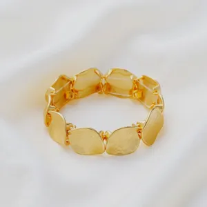 Detailed view of the geometric gold metal link bracelet showing its unique textured design.