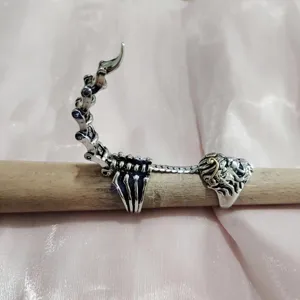 Punk zilveren schorpioen gewrichtsring detailopname met ingewikkelde botten en kristallen.