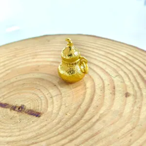 Close-up of a delicate gold gourd pendant showing exquisite texture and fine craftsmanship.