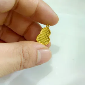 Detail view of a vintage gold-plated hulu gourd pendant showing its fine textured beaded surface.