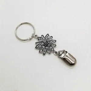 Vue détaillée du clip de chapeau en métal multifonctionnel avec pendentif fleur et pince.
