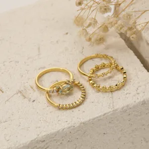 Elegante set di anelli impilabili dorati con zirconi scintillanti e pietra verde da donna.