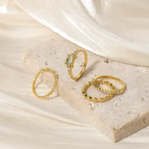 Set di 4 anelli in rame placcato oro con zirconi, dettaglio di gioielli eleganti.