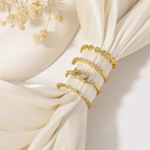 Elegante set di 4 anelli dorati con zirconi scintillanti e dettagli di foglie chic.