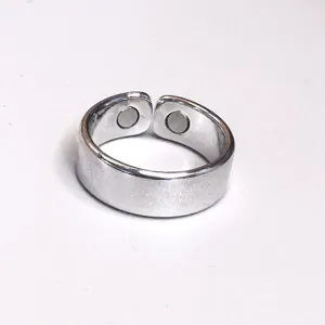 Close-up detail of silver adjustable magnetic therapy health ring with embedded round magnets.