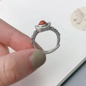 Vintage Thai silver sycee ring with red bead detail, detailed close-up shot of retro jewelry.