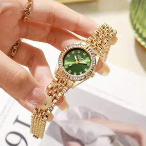 Primer plano del elegante reloj de cuarzo dorado con esfera verde y bisel con pedrería brillante.