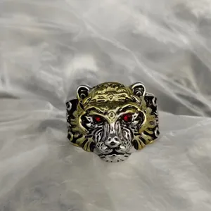 Exquisite tiger head ring detail showing intricate metal texture and red stone eyes.