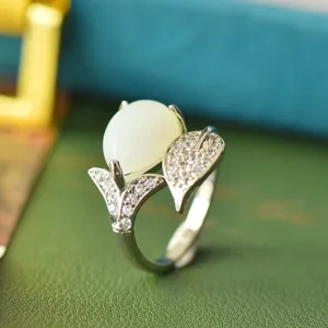 Detailopname van de vintage Thaise zilveren bladvormige ring met gladde witte jade en kristallen.