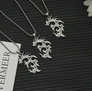 Close-up detail of men's gothic punk flame dragon pendant necklace with fine chain in silver tone.
