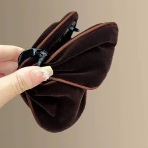 Detaillierte Nahaufnahme der braunen Samt Haarkralle mit weicher Textur und starkem Griff.