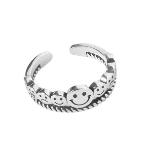 Detailed view of the vintage silver open ring featuring carved multiple smiley and sad faces.