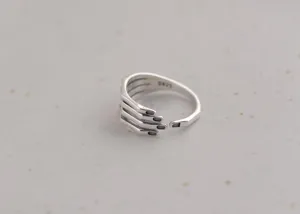 Detail shot of a creative silver hand shaped open ring, retro vintage style for women daily wear.