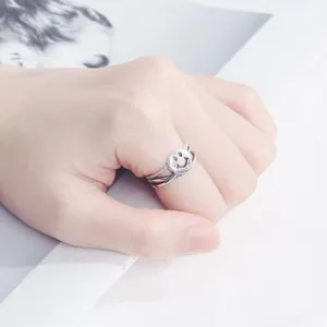 Close-up detail of silver smiley face open ring with double band and cute expression.