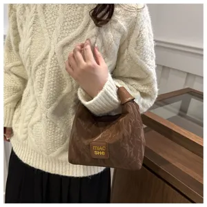 Detailansicht der lässigen braunen Umhängetasche mit einzigartiger Knitterstruktur.