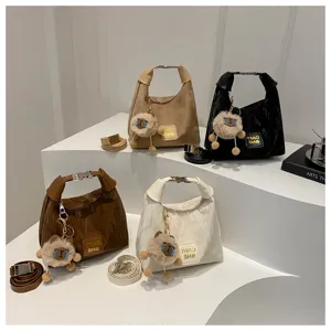 Stilvolle einfarbige Schultertasche mit Plüsch-Anhänger und verstellbarem Gurt für Damen.