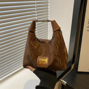 Sac sous-bras décontracté marron pour femme, sac à main minimaliste chic avec texture froissée.