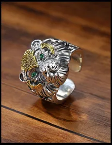 Close-up of the vintage silver tiger ring detail, showing carved texture and green eyes.