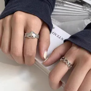 Gros plan détaillé de bagues tendance en argent en forme de cœur, bijoux élégants et stylés.