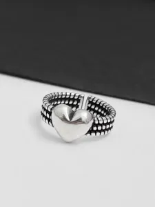 Vue détaillée de la bague cœur en argent avec cœur en relief et anneau ouvert texturé.