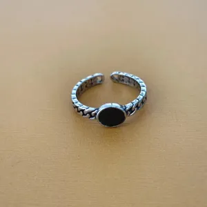 Close-up van retro open ring met zwarte cirkel en kettingband detail voor dagelijks gebruik.