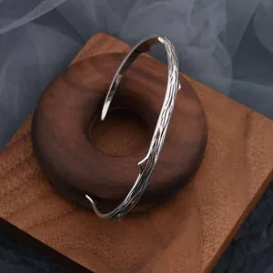 Detail shot of vintage silver thorn open bangle, minimalist couple jewelry, chic minimalist style.