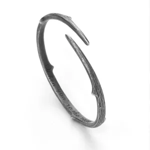 Vintage thorn branch open metal bracelet, couple minimalist gothic jewelry detail shot.