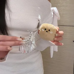 Detailansicht des Guizhou Kartoffel Plueschpuppen Anhaengers mit Ethno-Silberschmuck.
