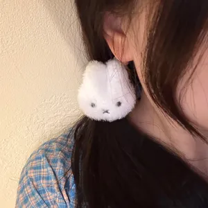 Primo piano del grazioso elastico per capelli con coniglietto peloso bianco. Accessorio dolce.